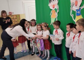 grupa dzieci na tle zielonej dekoracji konkurs piosenki wręczenie dyplomu