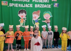 grupa dzieci na tle zielonej dekoracji konkurs piosenki