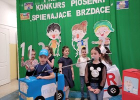 grupa dzieci na tle zielonej dekoracji konkurs piosenki