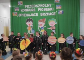 grup dzieci na tle zielonej dekoracji konkurs piosenki