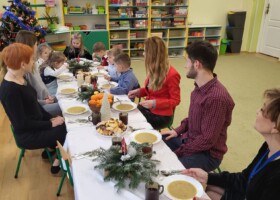 Dzieci i nauczyciele przedszkola przy stole podczas obiadu wigilijnego