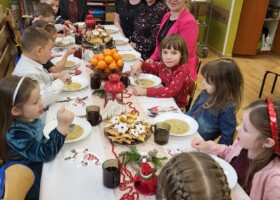 Dzieci i nauczyciele przedszkola przy stole podczas obiadu wigilijnego