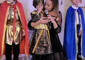 Chłopcy przebrani za trzech króli i nauczycielka występują podczas Jasełek