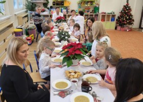 Dzieci i nauczyciele przedszkola przy stole podczas obiadu wigilijnego