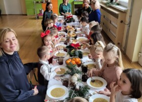 Dzieci i nauczyciele przedszkola przy stole podczas obiadu wigilijnego