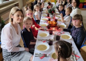 Dzieci i nauczyciele przedszkola przy stole podczas obiadu wigilijnego