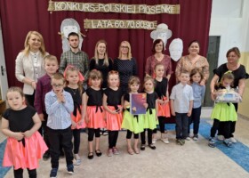 Grupa dzieci z nauczycielami na holu przedszkolnym po odebraniu nagrody w konkursie Polskiej Piosenki