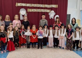 Grupa dzieci z nauczycielami na holu przedszkolnym po odebraniu nagrody w konkursie Polskiej Piosenki